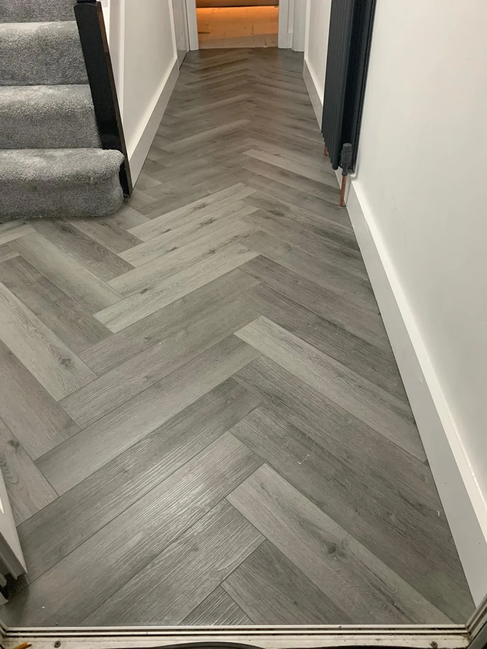 Grey herringbone laminate in a hallway