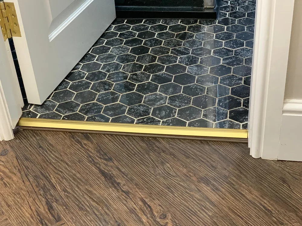 Wood-effect laminate meeting hexagon tiles