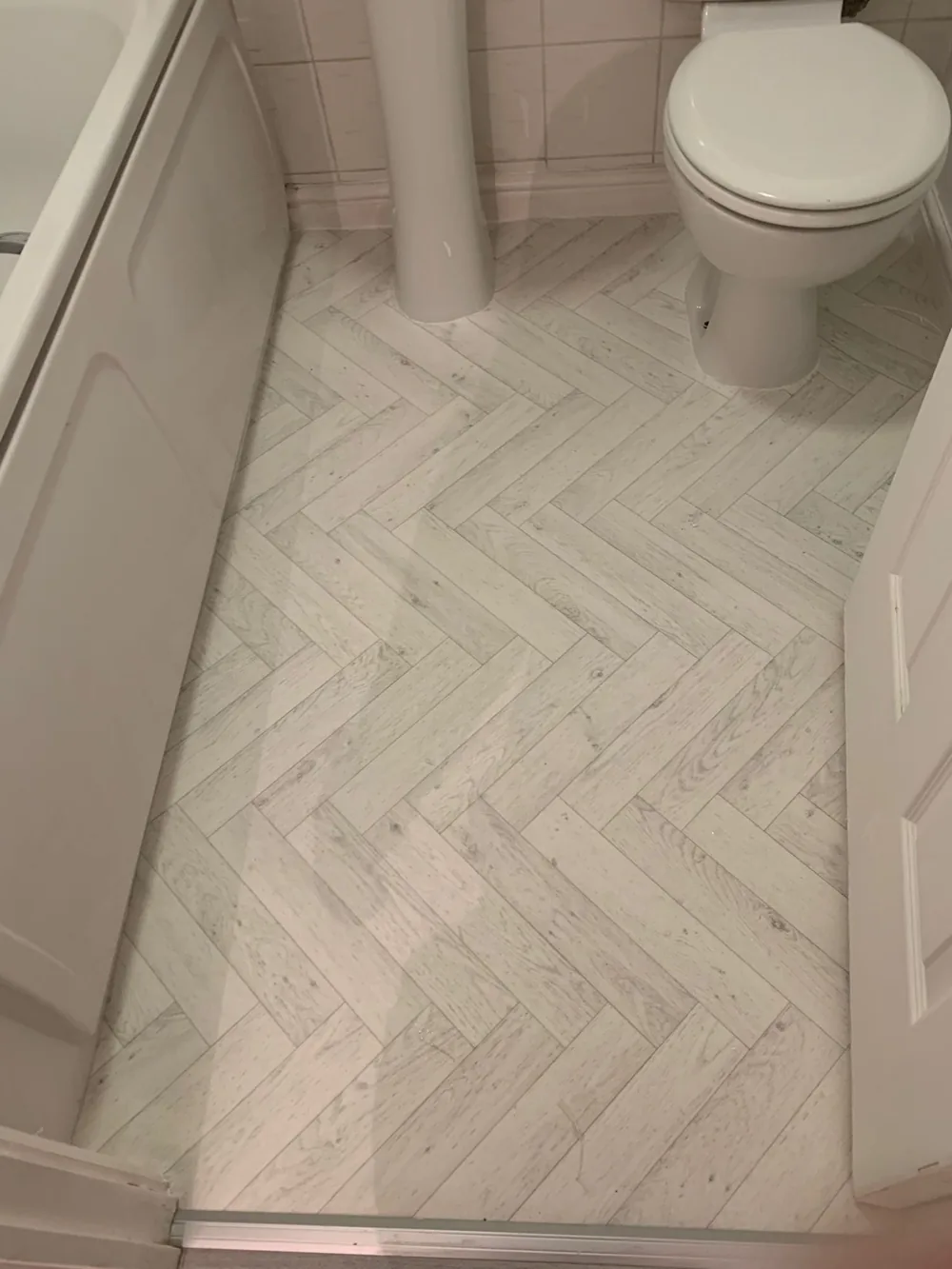 White herringbone LVT in a bathroom